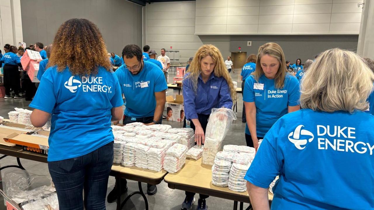 Volunteers stacking diapers at tables.
