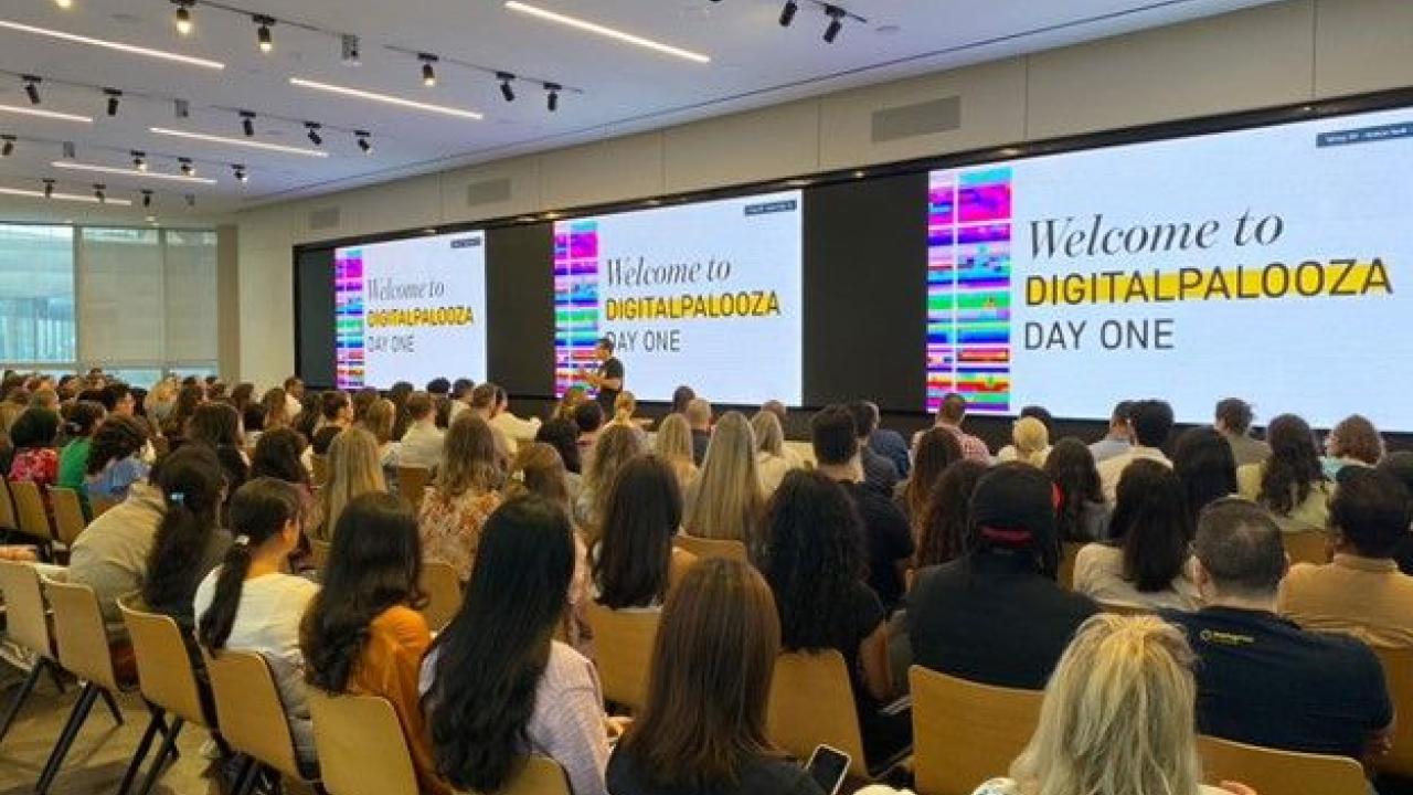 a large room of seated people "welcome to digitalpalooza" on the screen