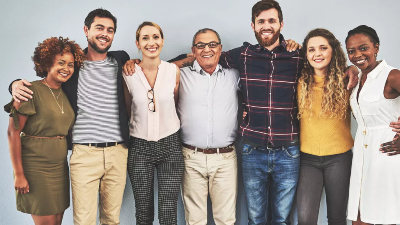 A group of people with their arms over each others' shoulders.