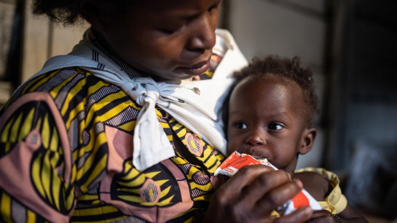 A mother feeds her young child Plumpy'Nut, the peanut butter-like paste used to treat malnutrition.