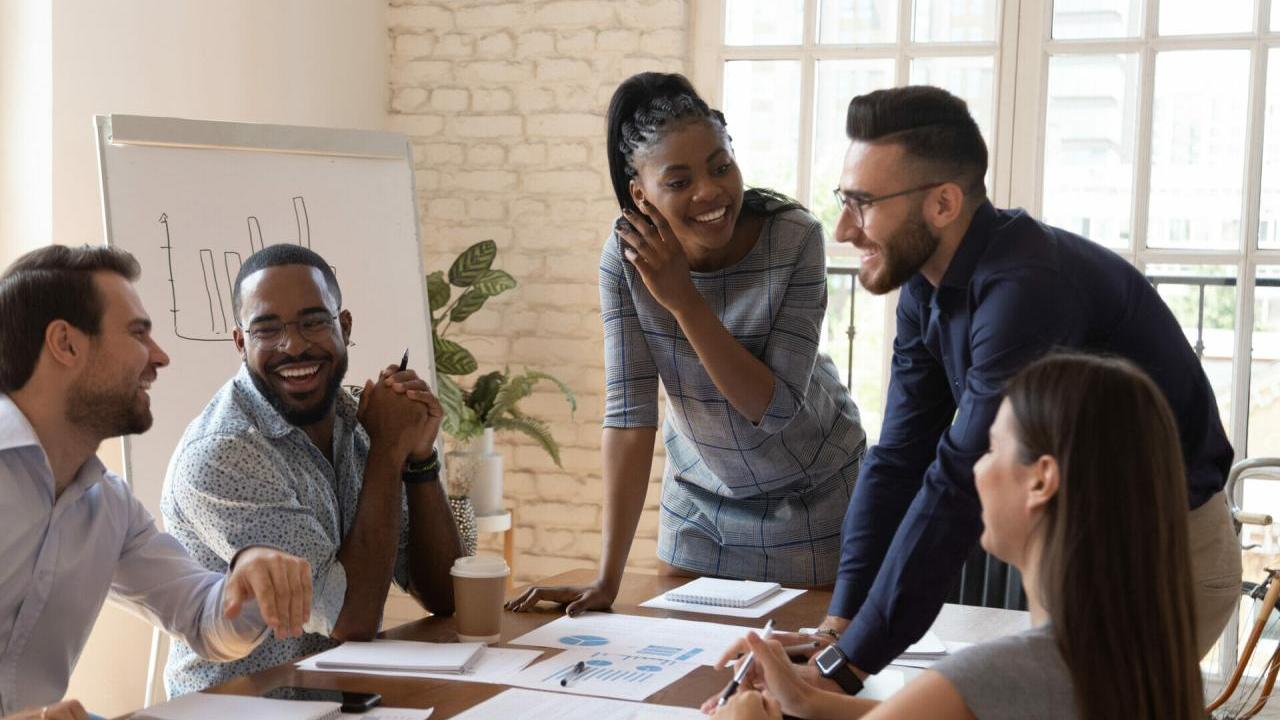 Coworkers talking and laughing at a conference table