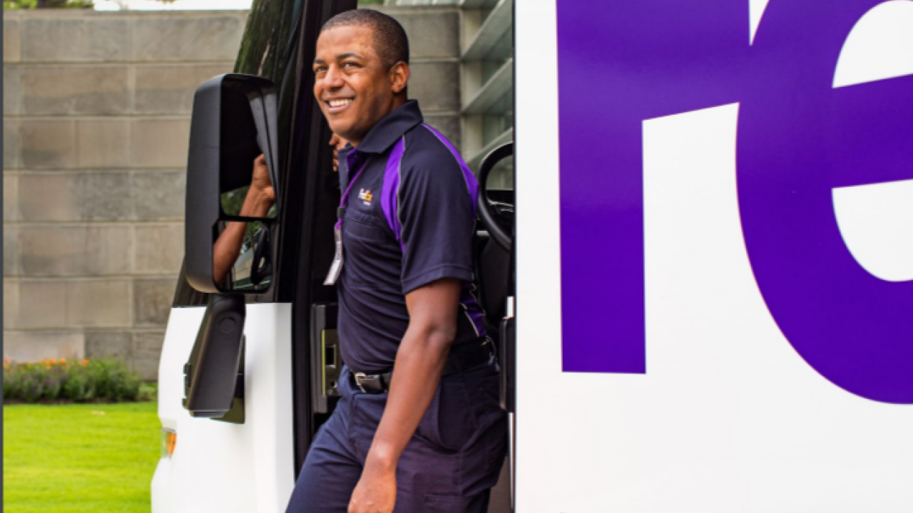 a driver steps out of a FedEx truck