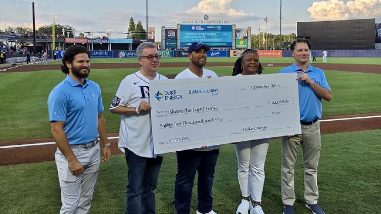 people holding up a large version of a check
