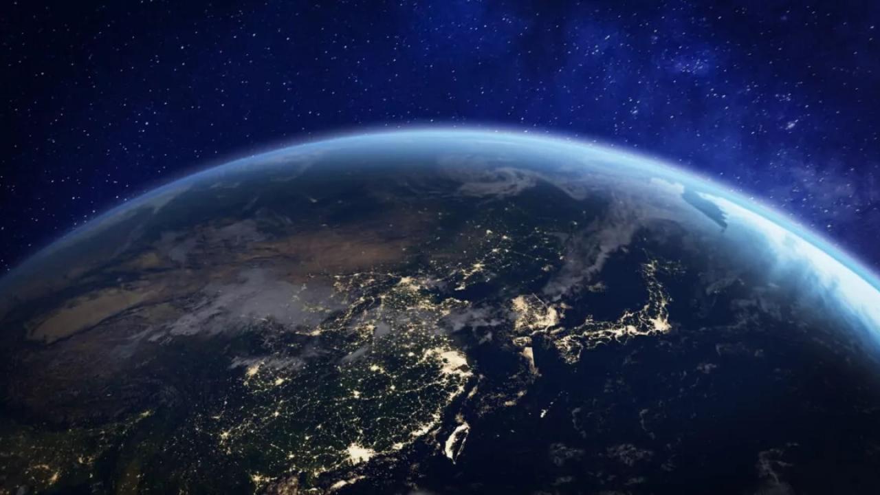 The Earth in outer space. Lights from cities visible.