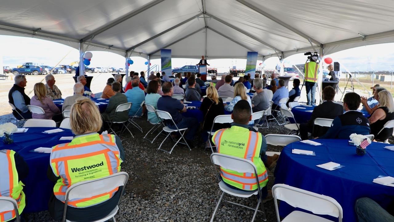 audience sitting under a tent 