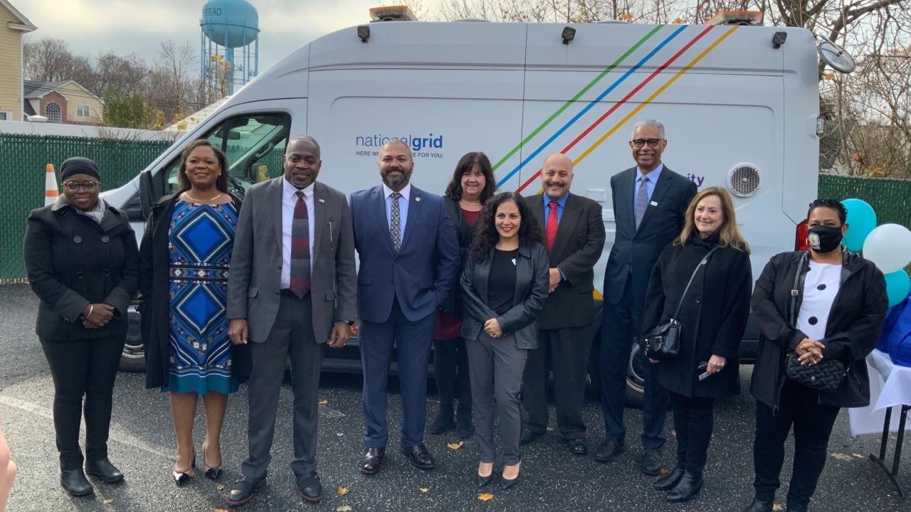 group of people posing in front of a National Grid truck