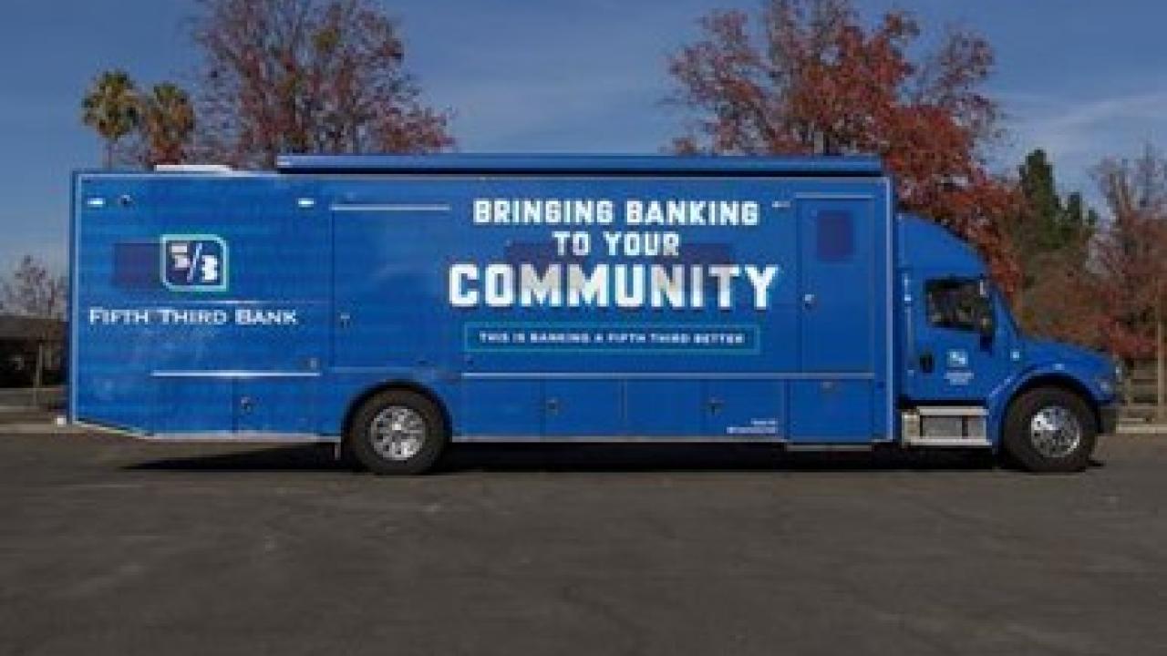 A semi trailer in all blue with "Bringing banking to your community" on the side with 5/3 logo.