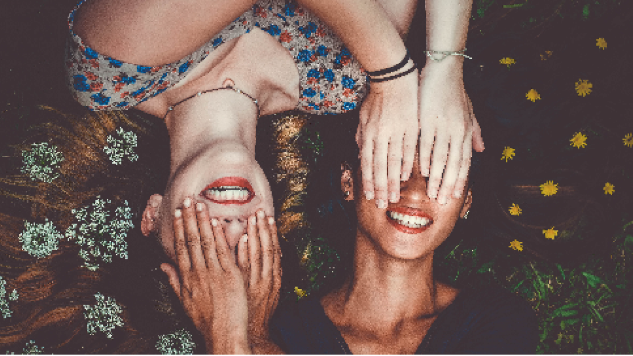 Two women both covering their eyes.