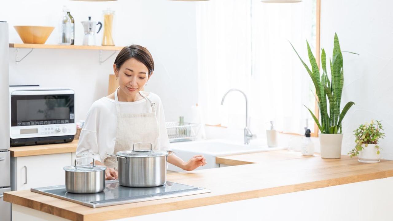 person in white cooking on an electric range