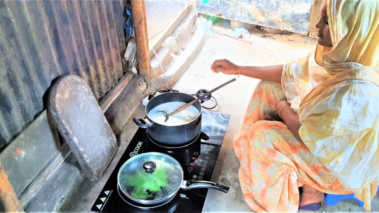 Person cooking with two pans on an electric stove