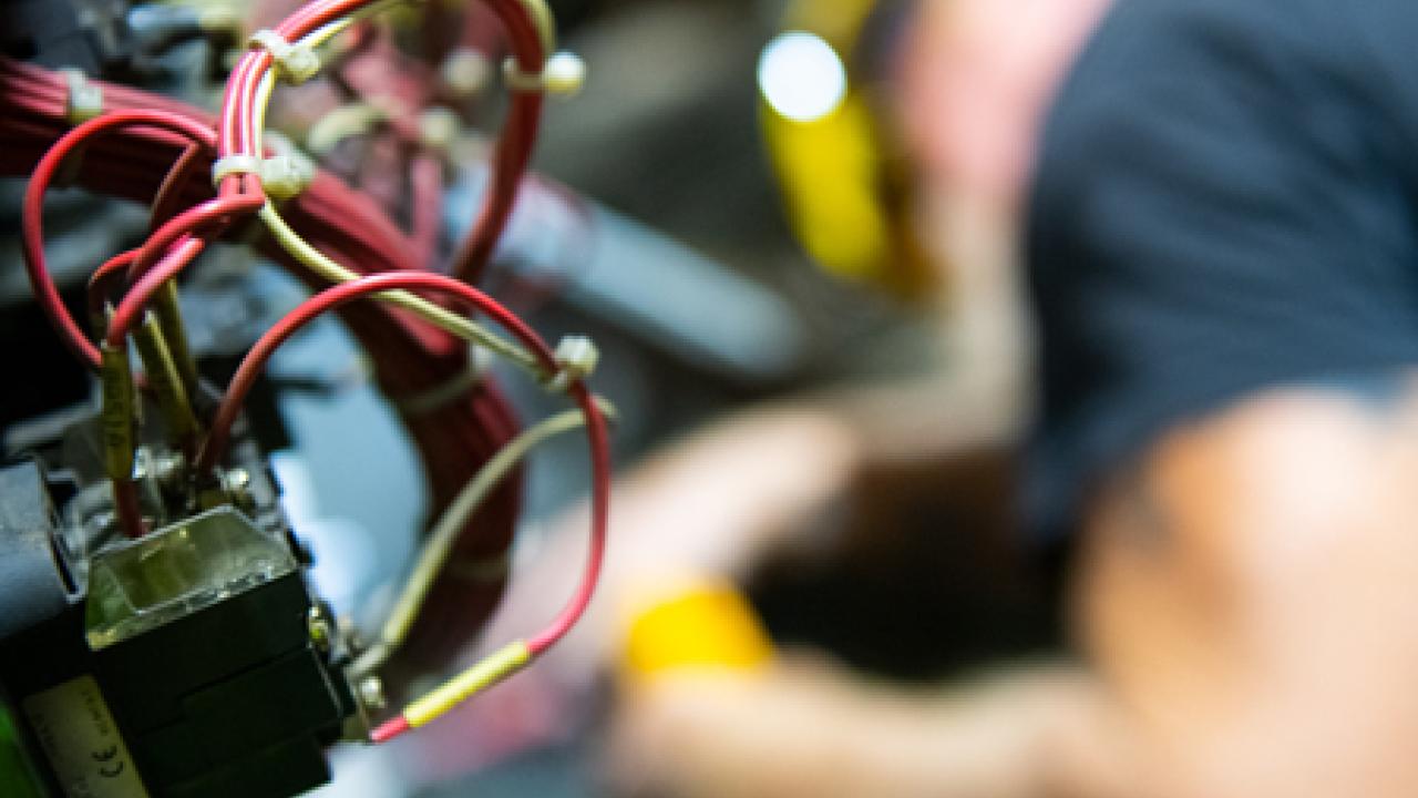 electrician, out of focus, with wiring in the foreground