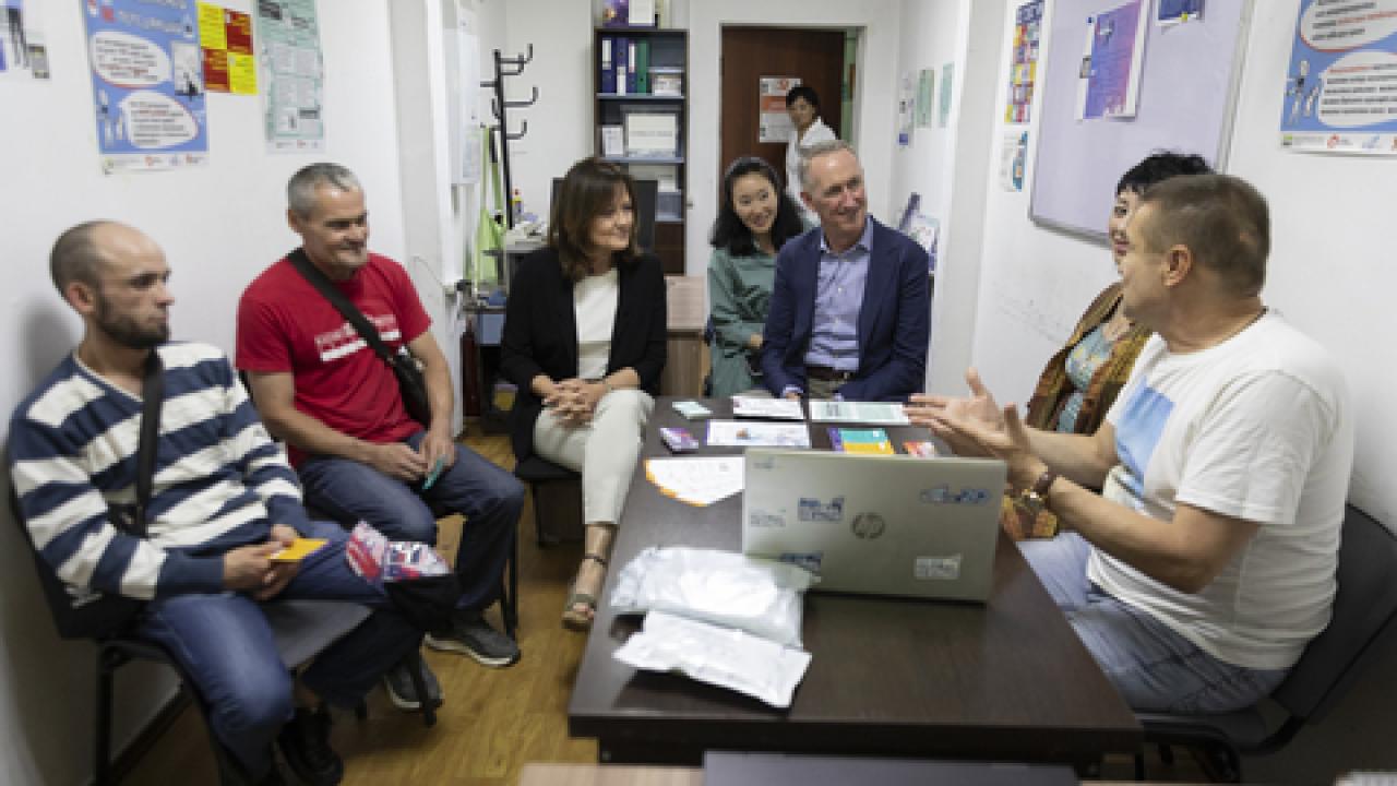 People sitting and having a discussion around a table.