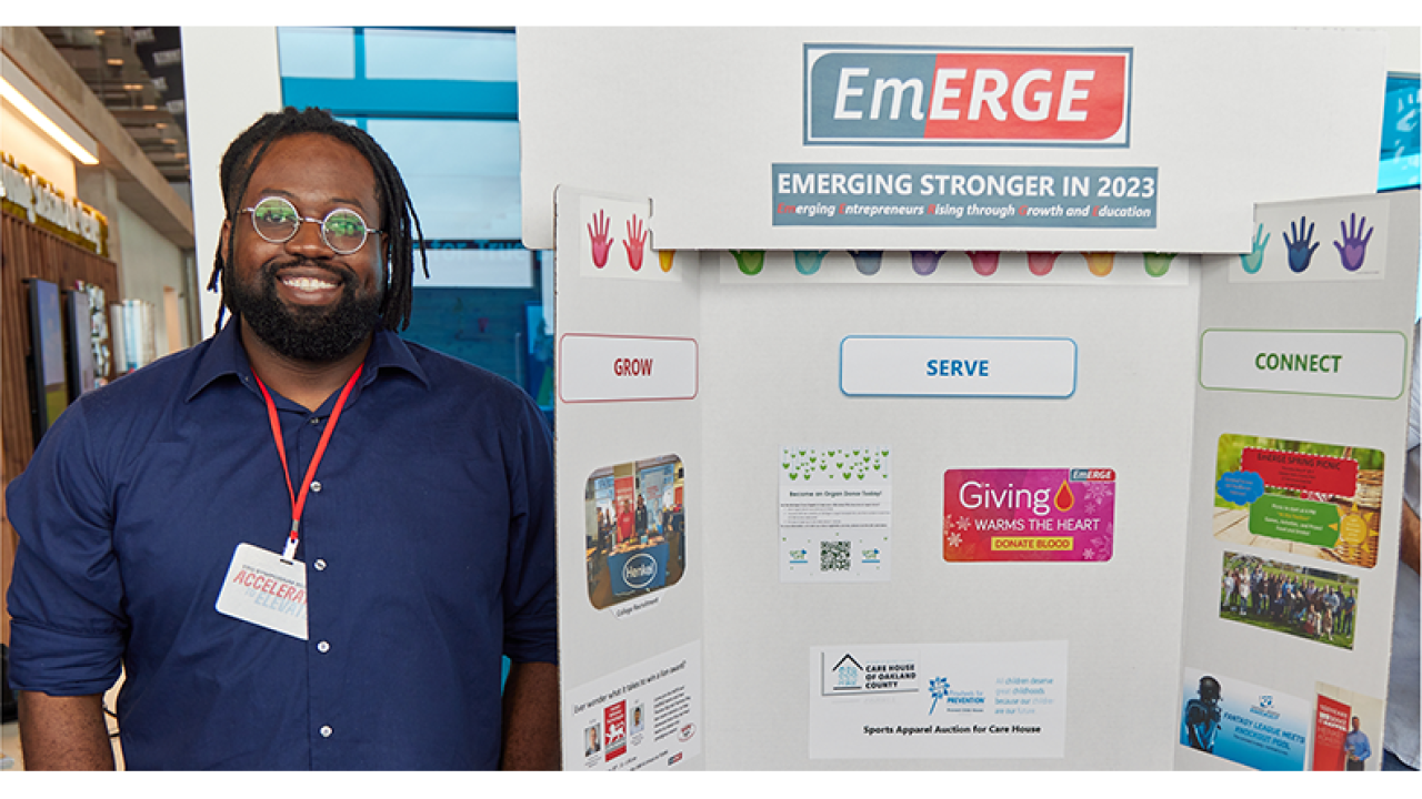 Henkel employee with an EmERGE poster