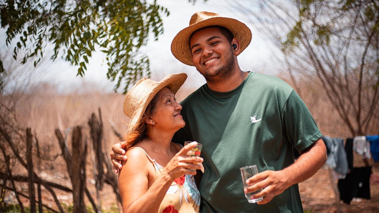Two people standing together with glasses of water