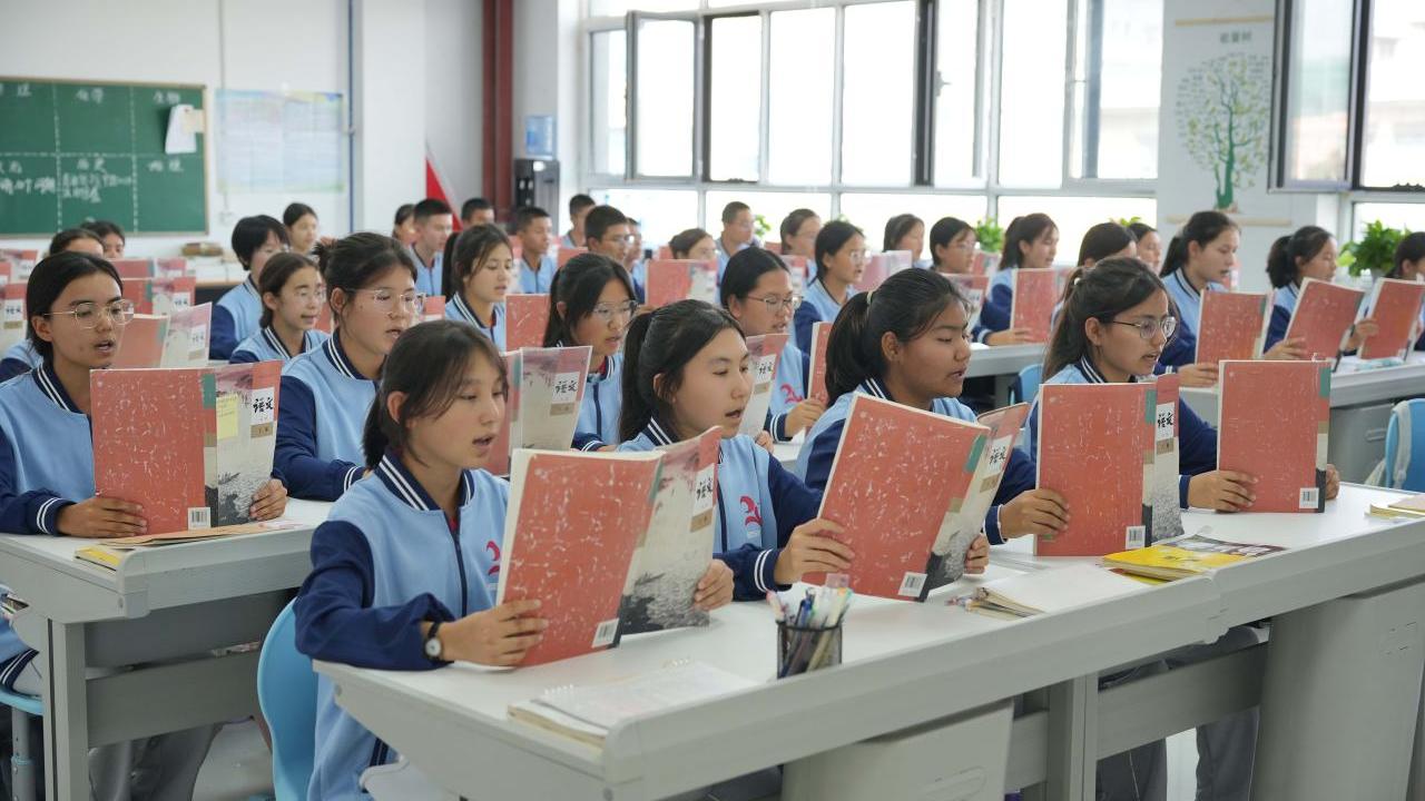 Students sitting in a classroom reading from books