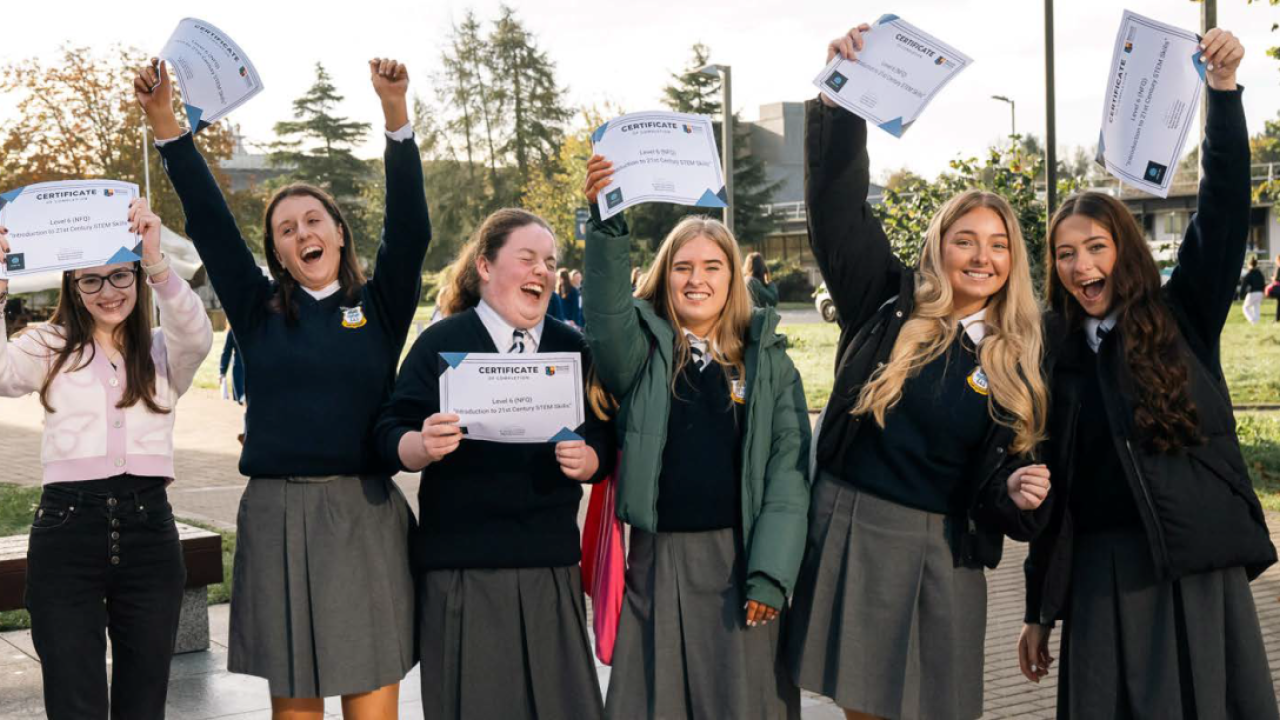6 people raising diplomas and cheering