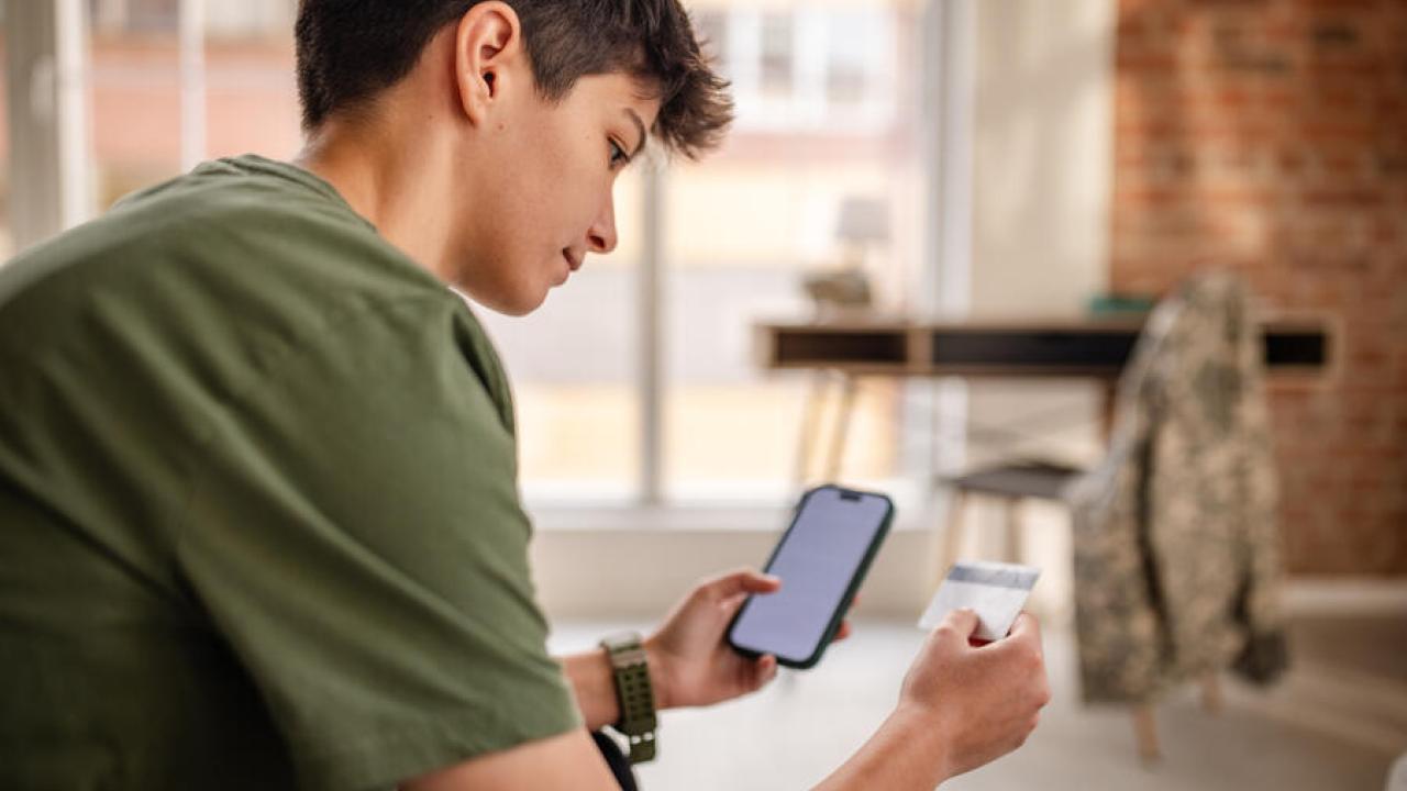 person looking at a card and their phone