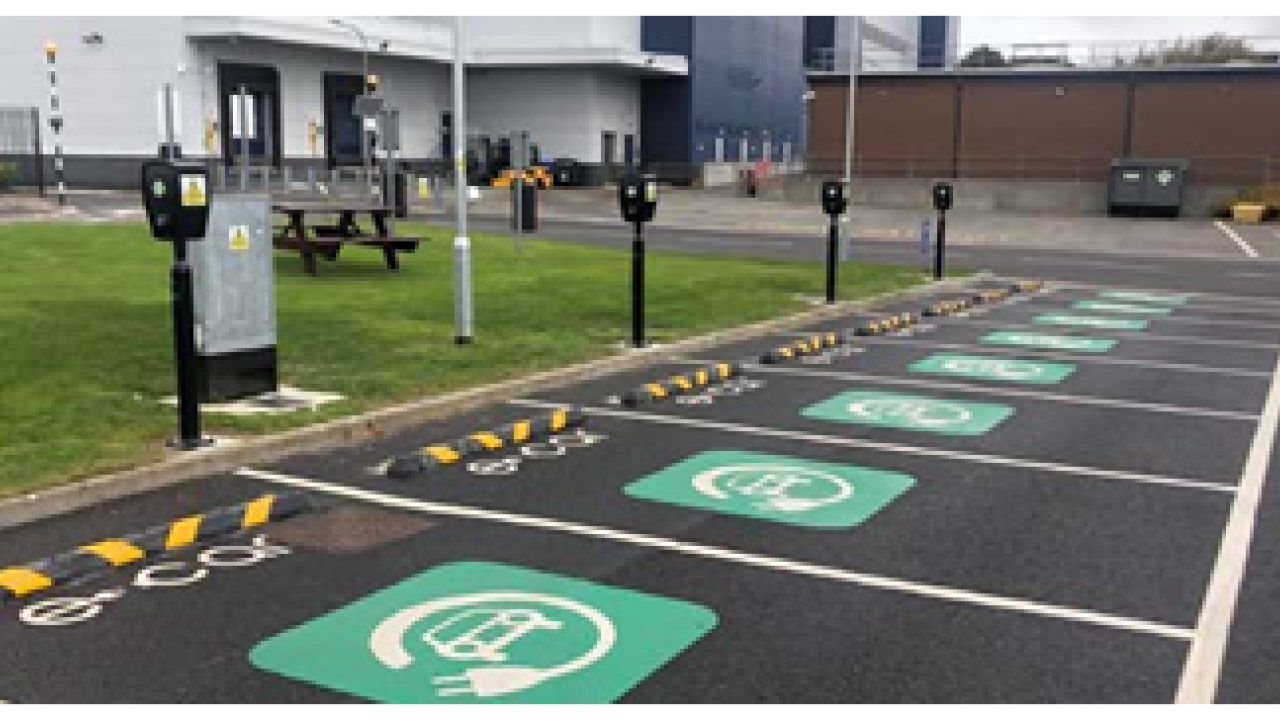 A parking lot with a row of EV charging stations.