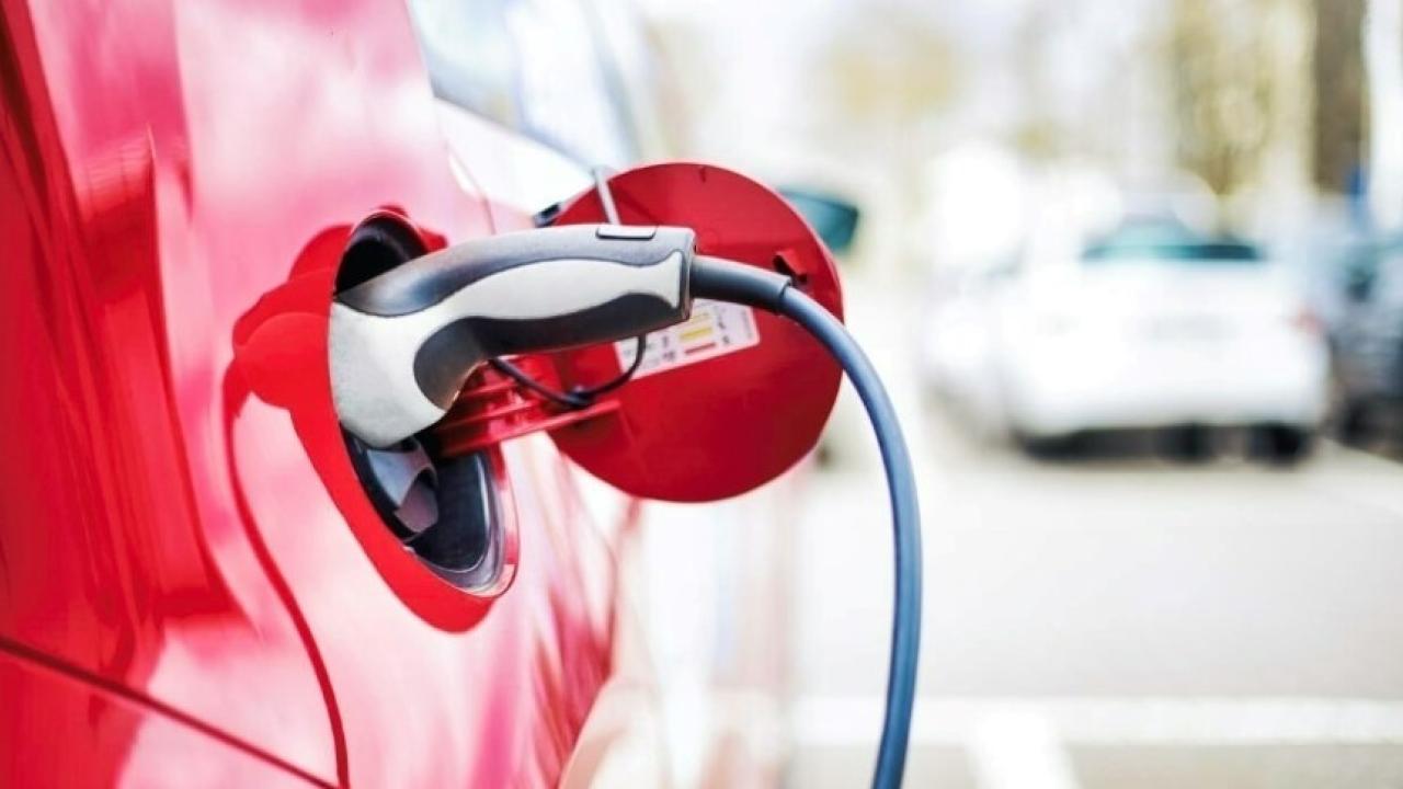 A red electric vehicle plugged in.