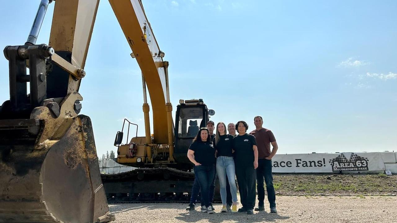 Group of people next to a large piece of construction equipment