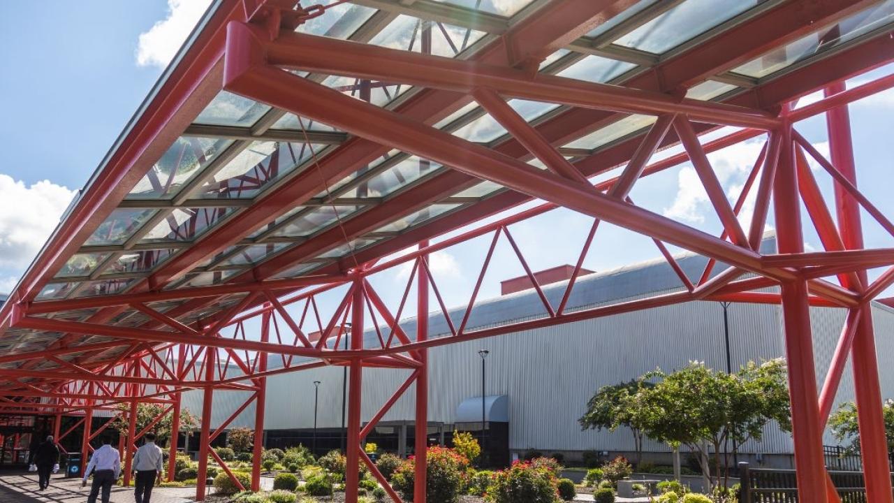 Exterior red support beams covering a walkway.