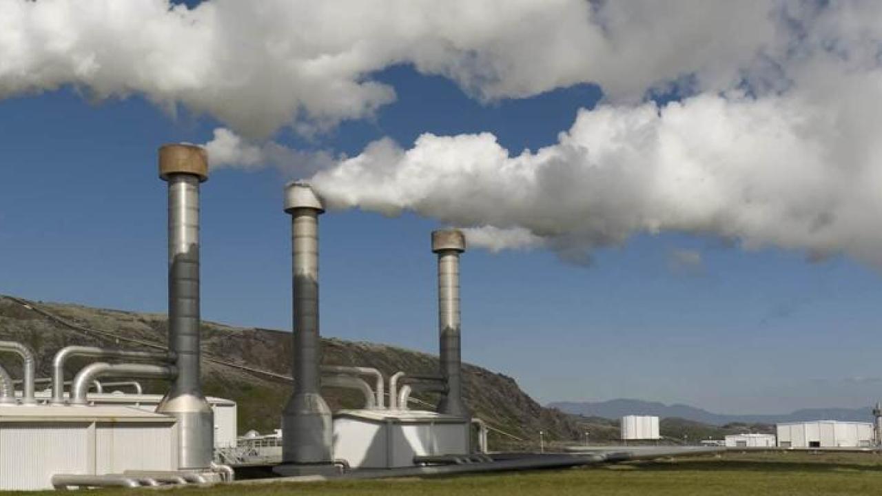factory with exhaust coming out in front of a blue sky