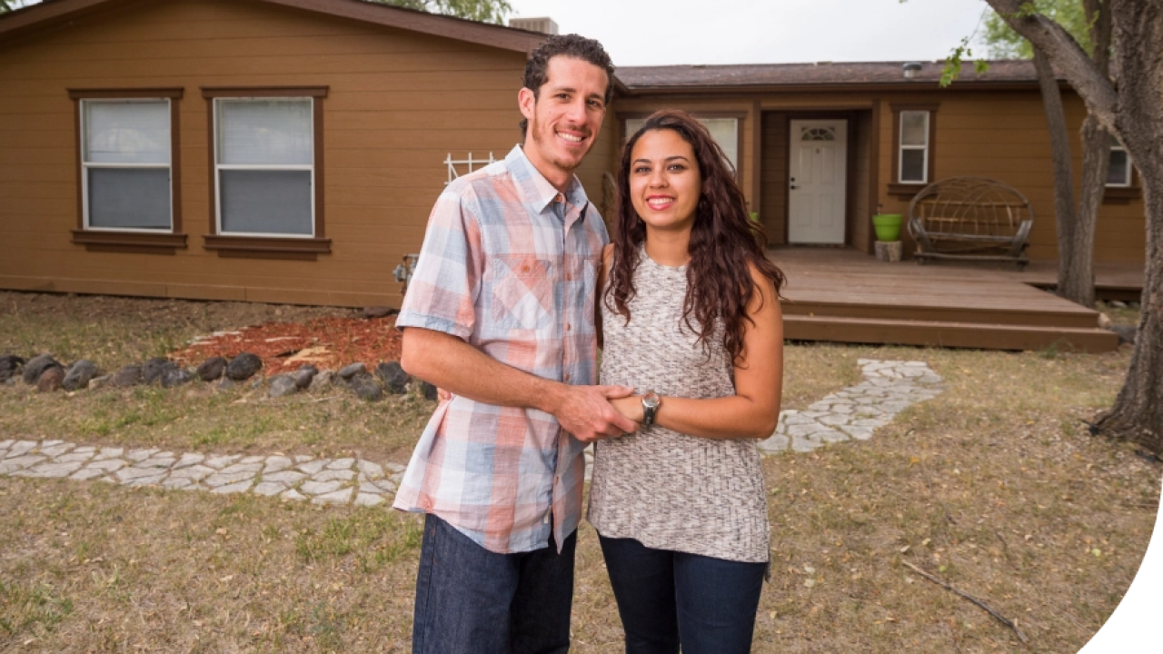 Couple standing in front of a house