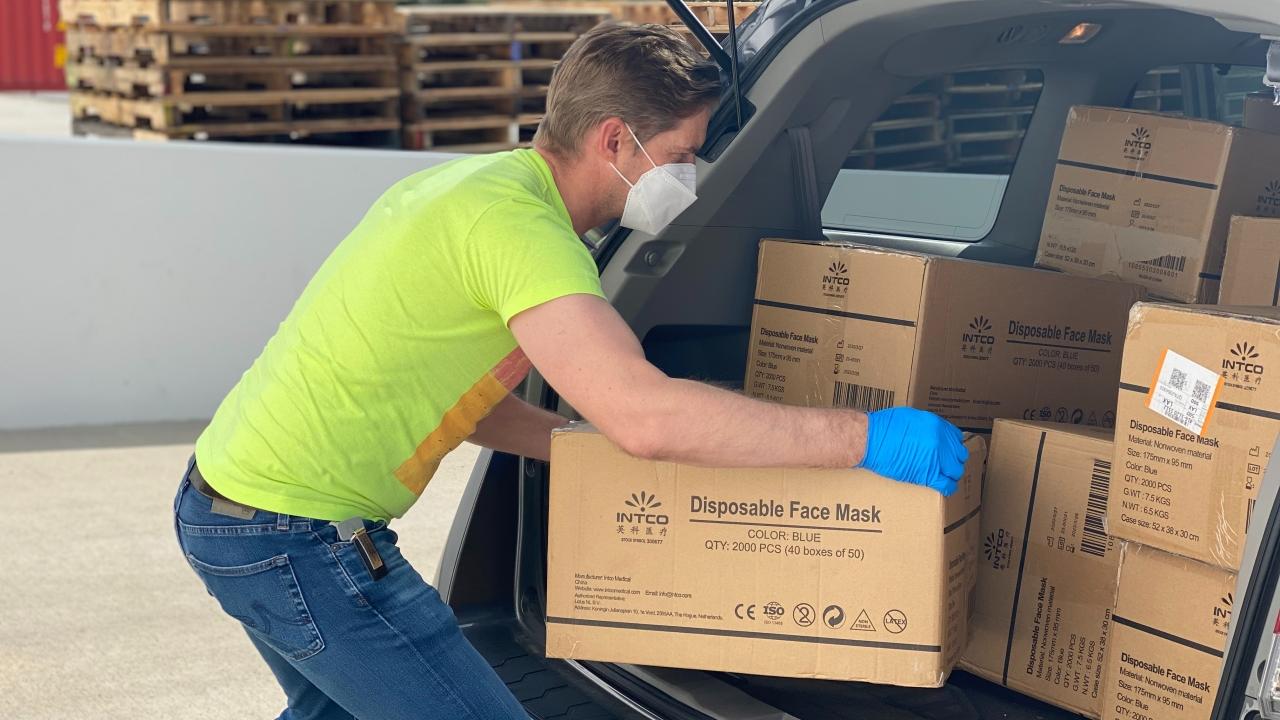 Man loading boxes in a car.