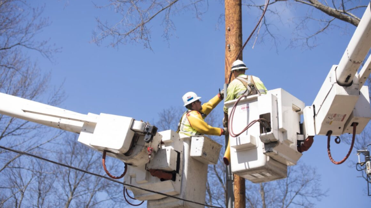 Workers in cherry pickers working together