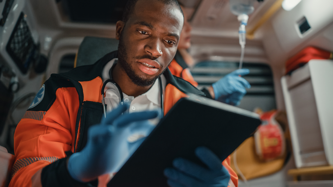 a first responder using a tablet in the back of an ambulance