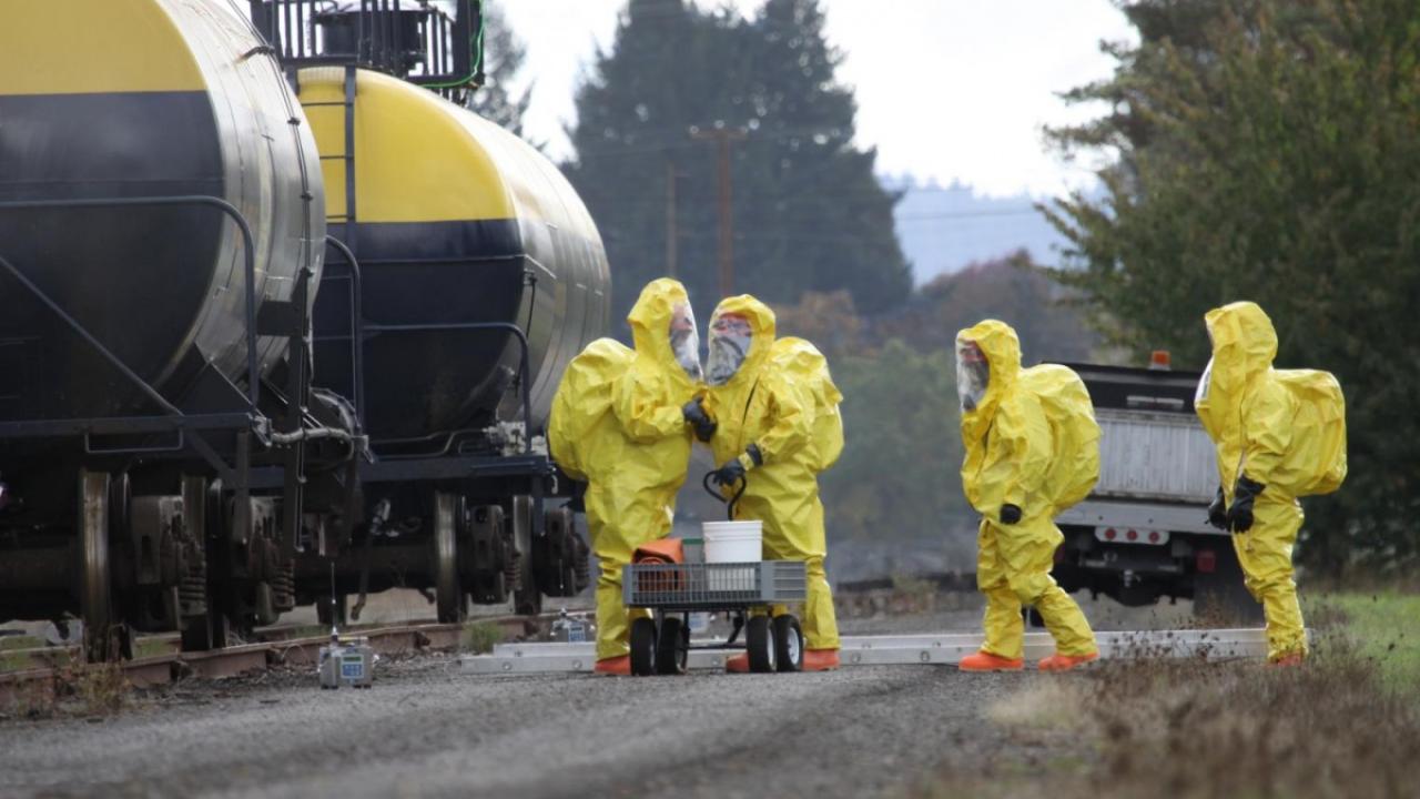 4 emergency responders in full yellow protective suits