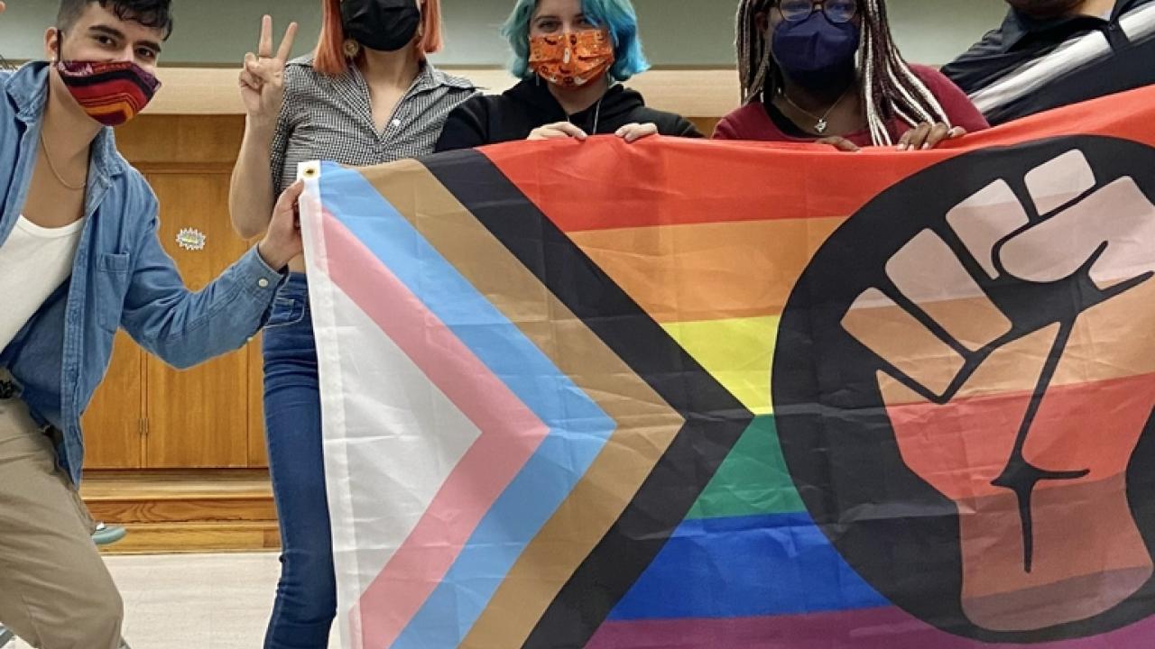 Latino Equity Alliance group with a LGBTQ+ flag
