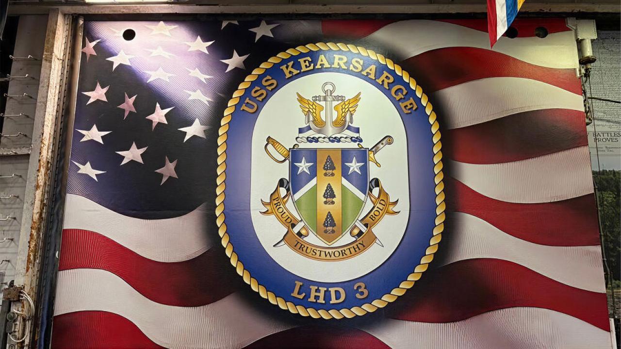 American flag with emblem for USS Kearsarge on top