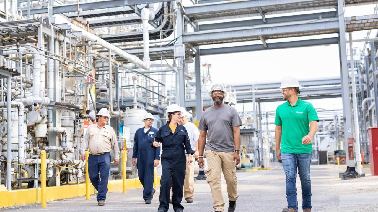 People in hardhats walking through a plant