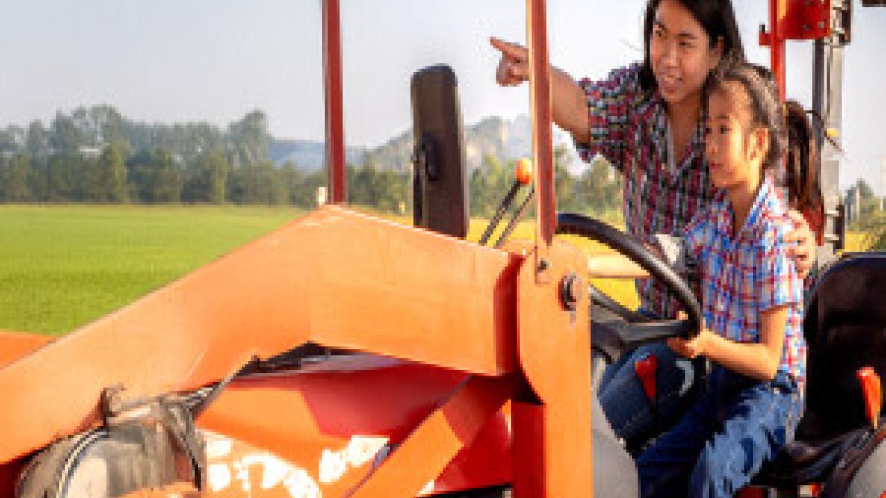An adult and a child on a tractor