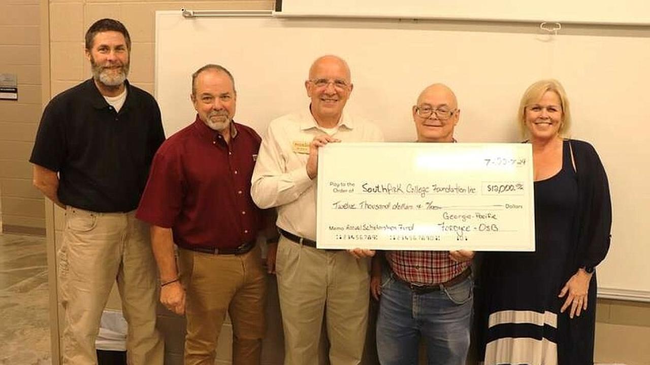 Five people holding an oversized check