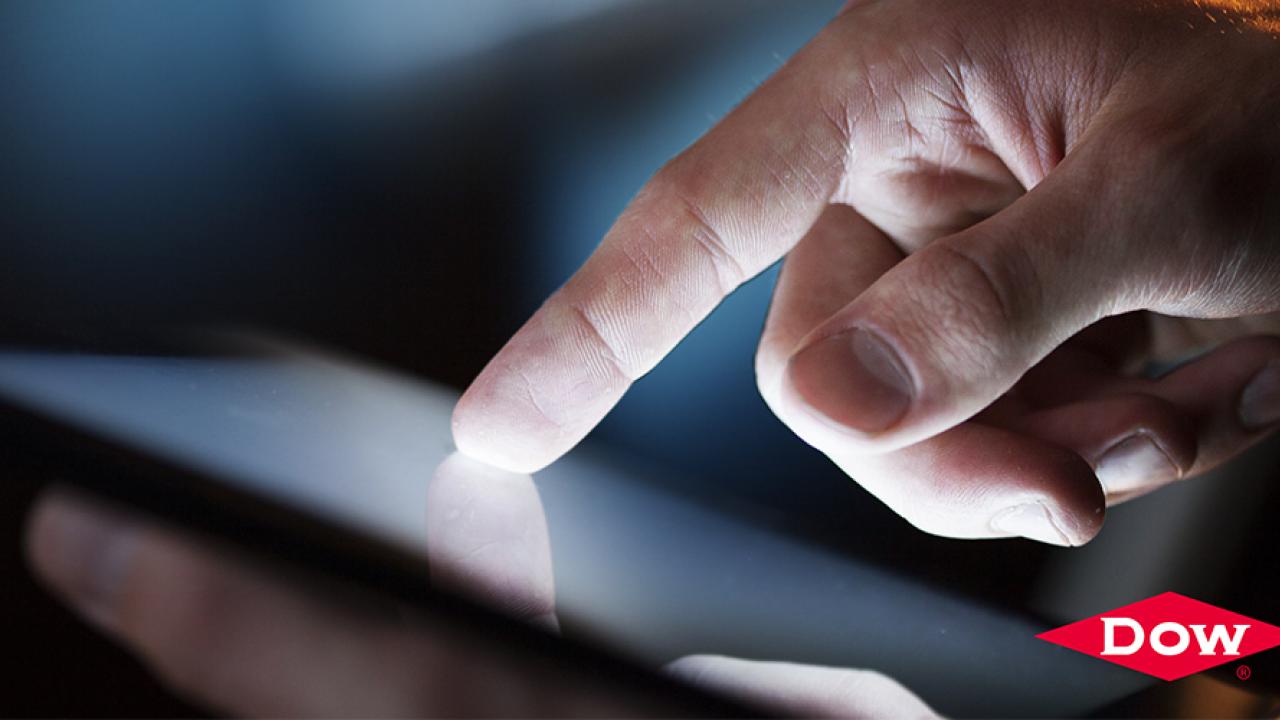 finger touching a device screen, Dow logo in the corner