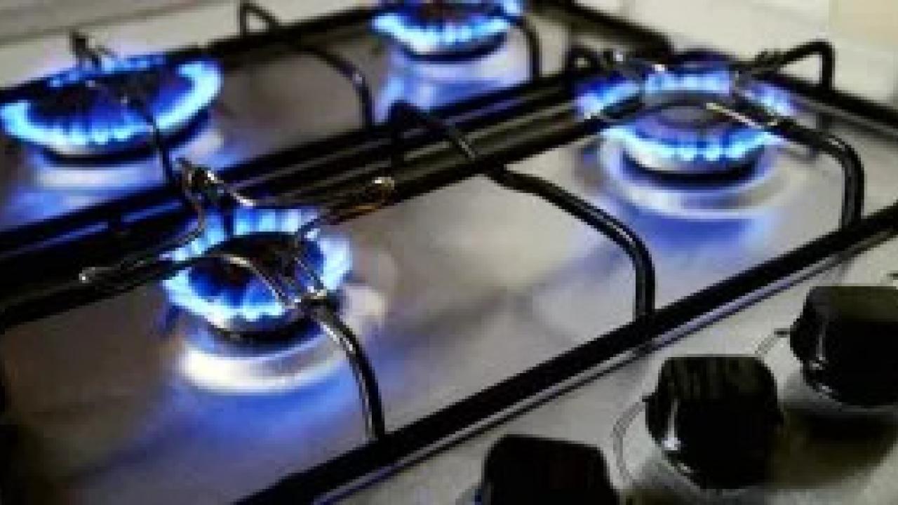 A gas range with all four burners on.
