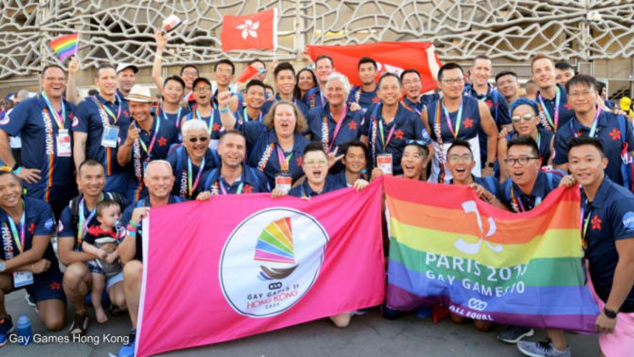 Large group of people with LBGTQ+ Flag and Gay Games Flag