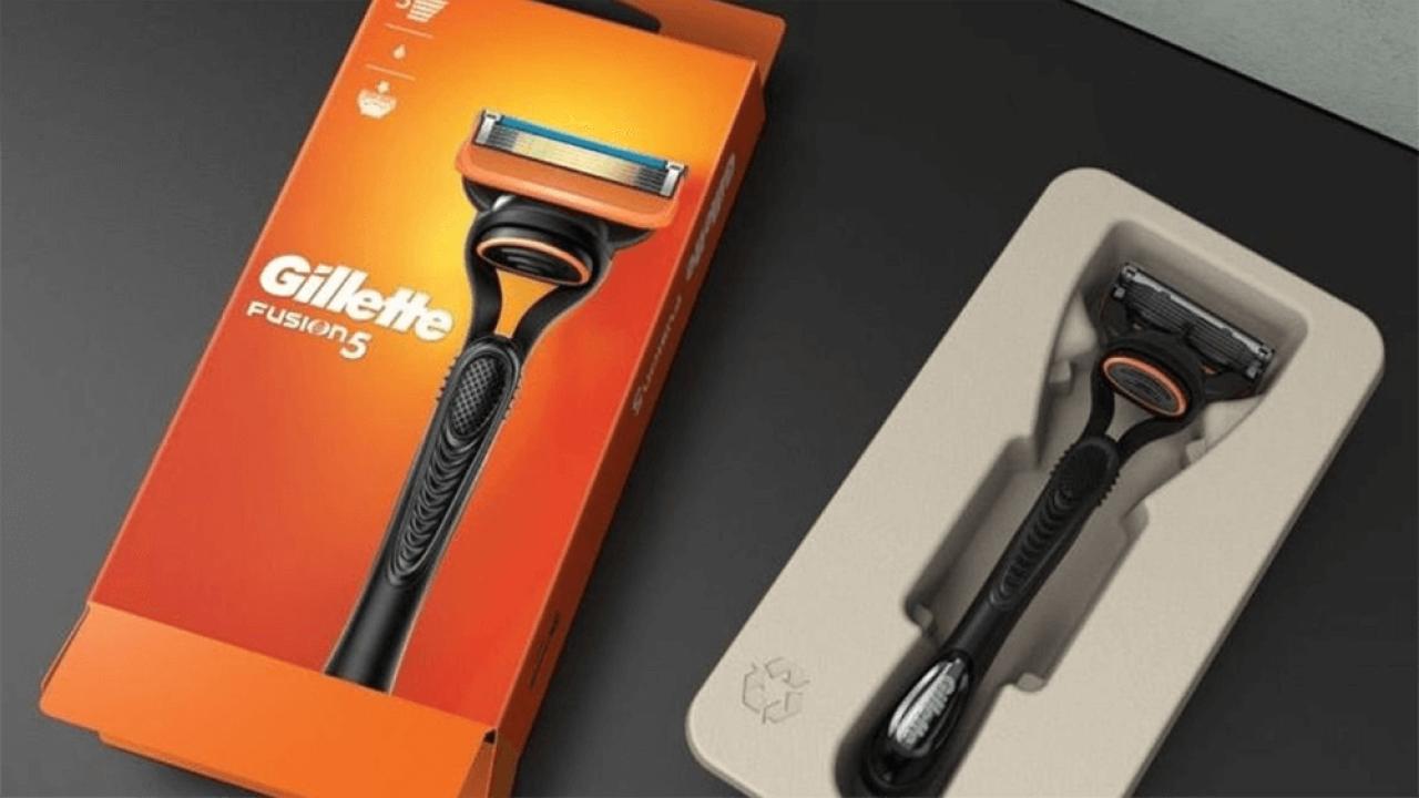 An orange box with Gillette logo and picture on a razor, on the right the product in a cardboard holding box.