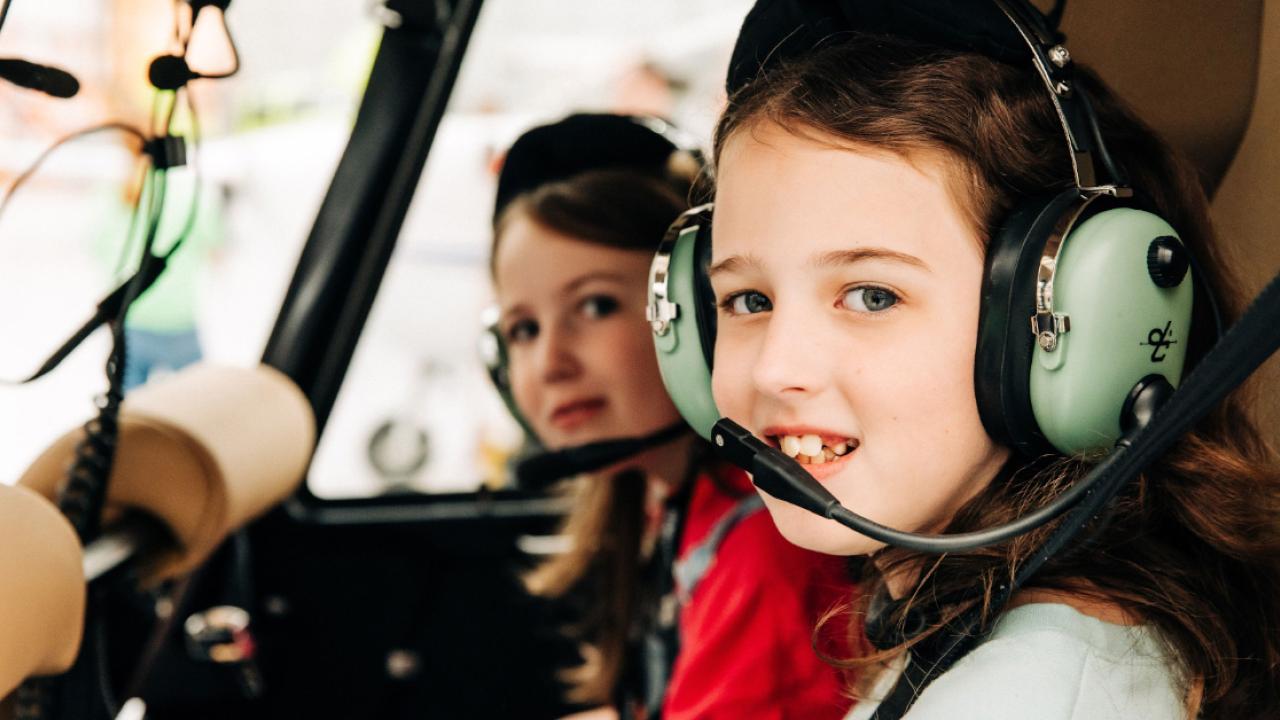 two children sitting in a plane wearing headphones