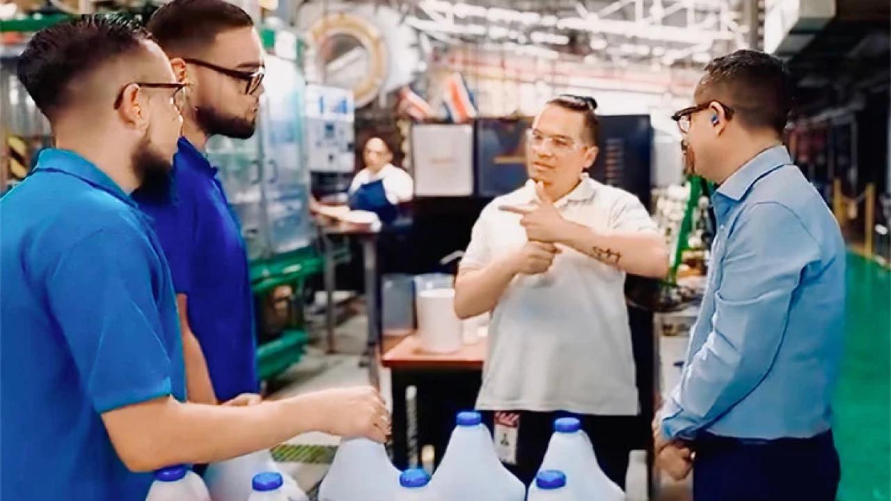 Jorge speaking with sign language to three other employees.