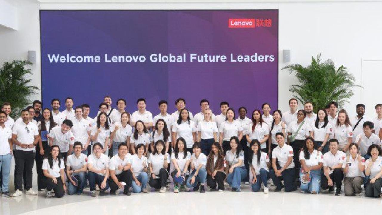 A group posed in matching shirts in front of a sign "Welcome Lenovo Global Future Leaders"