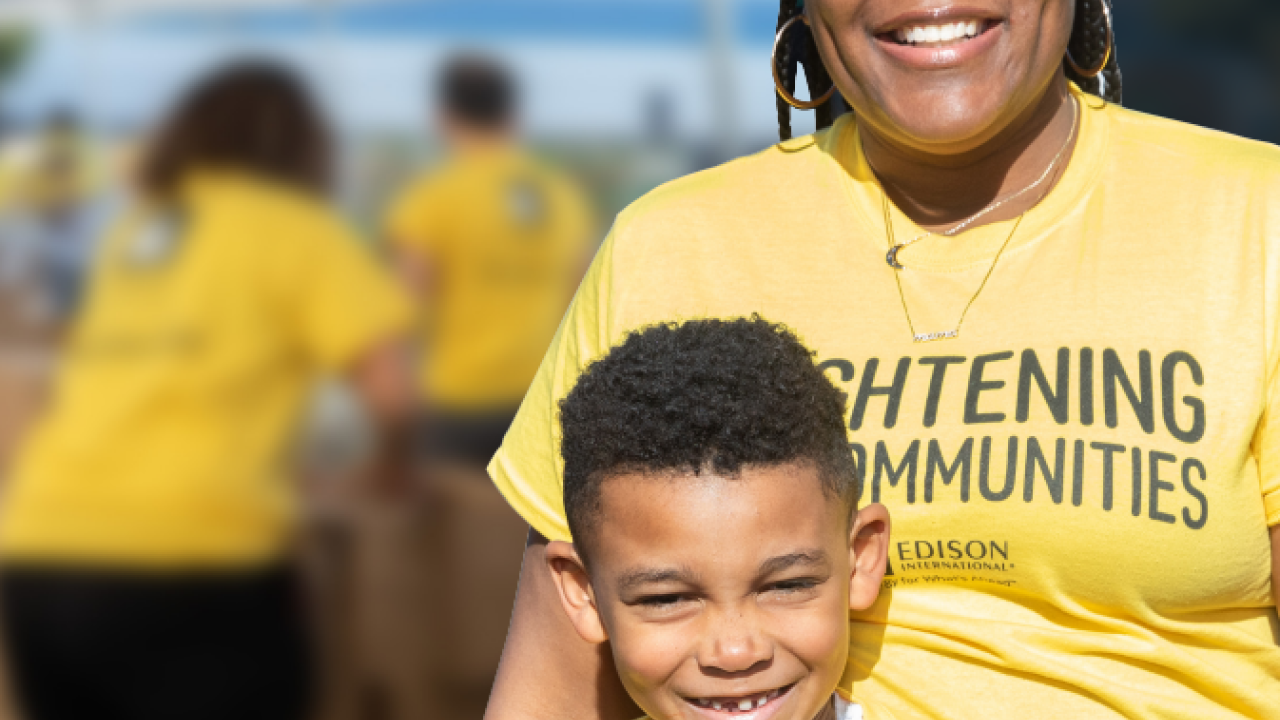 An adult and child smiling in matching tshirts.