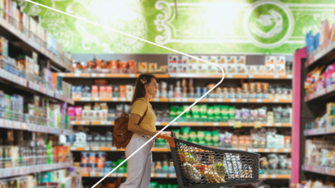 a person pushing a grocery cart in a store, aisles filled with food