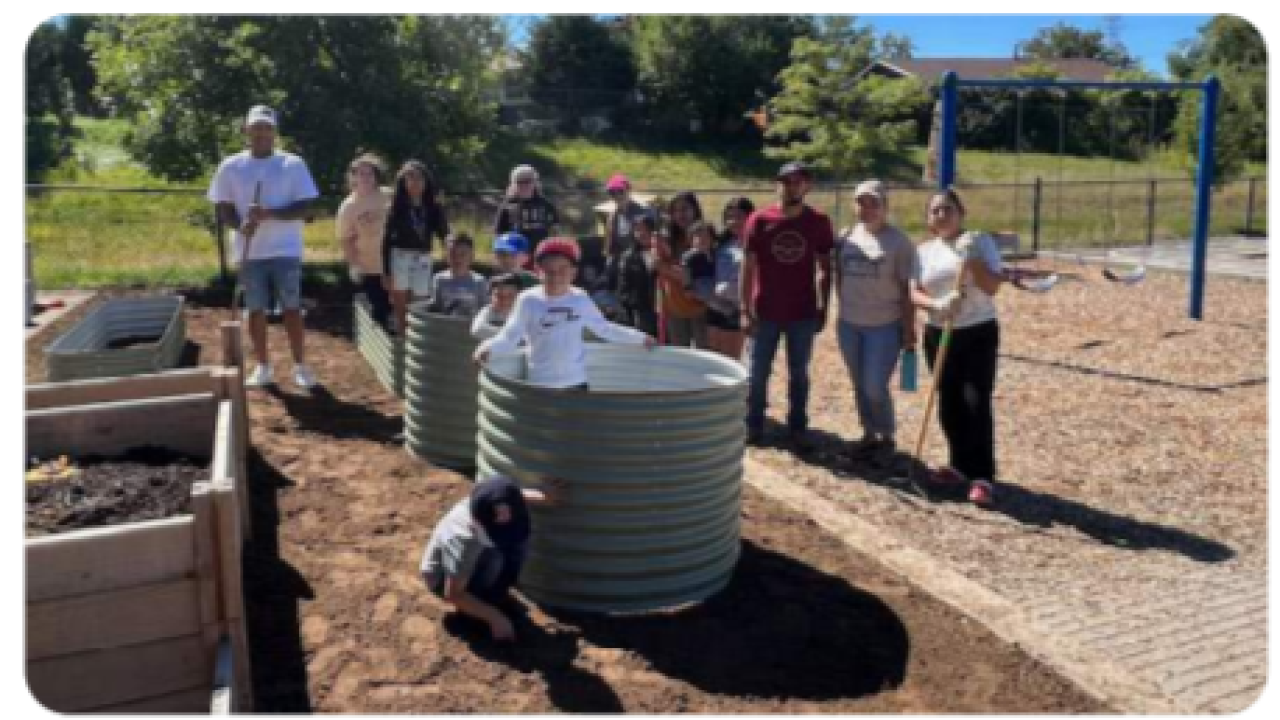 Adults and kids working on a playground/garden area.