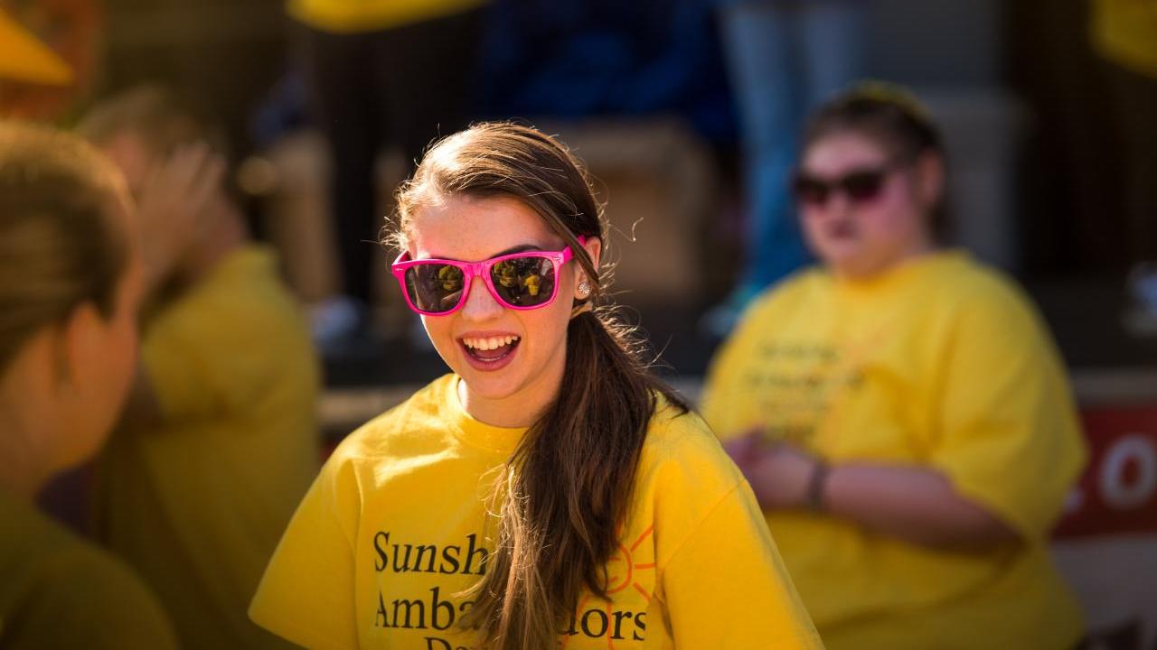 person smiling in a yellow tshirt