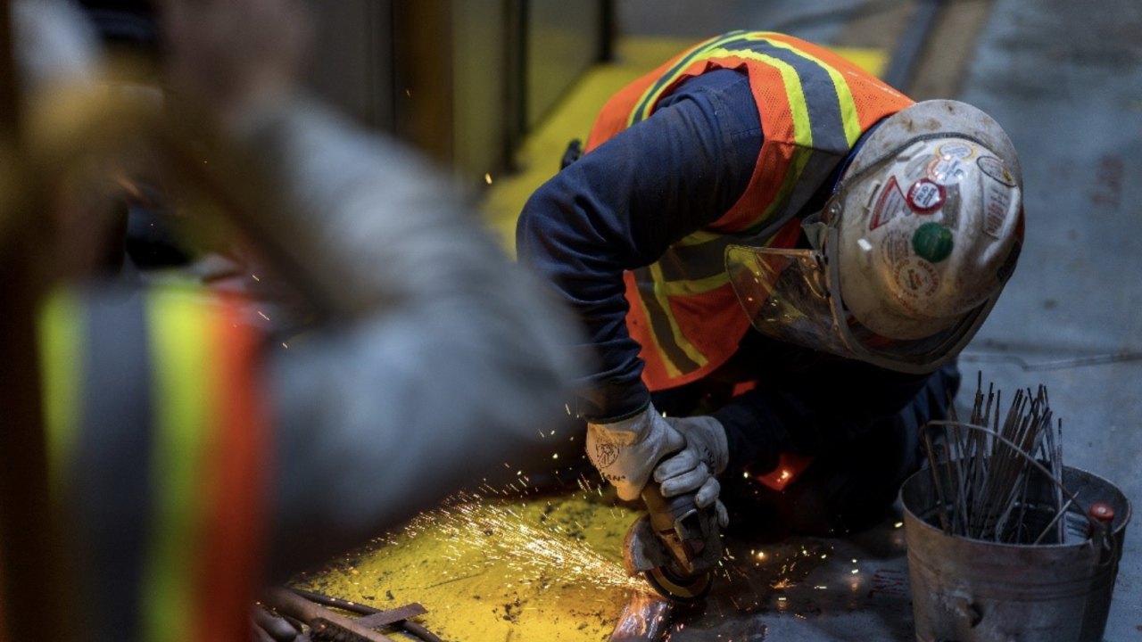worker in safety gear using an angle grinder