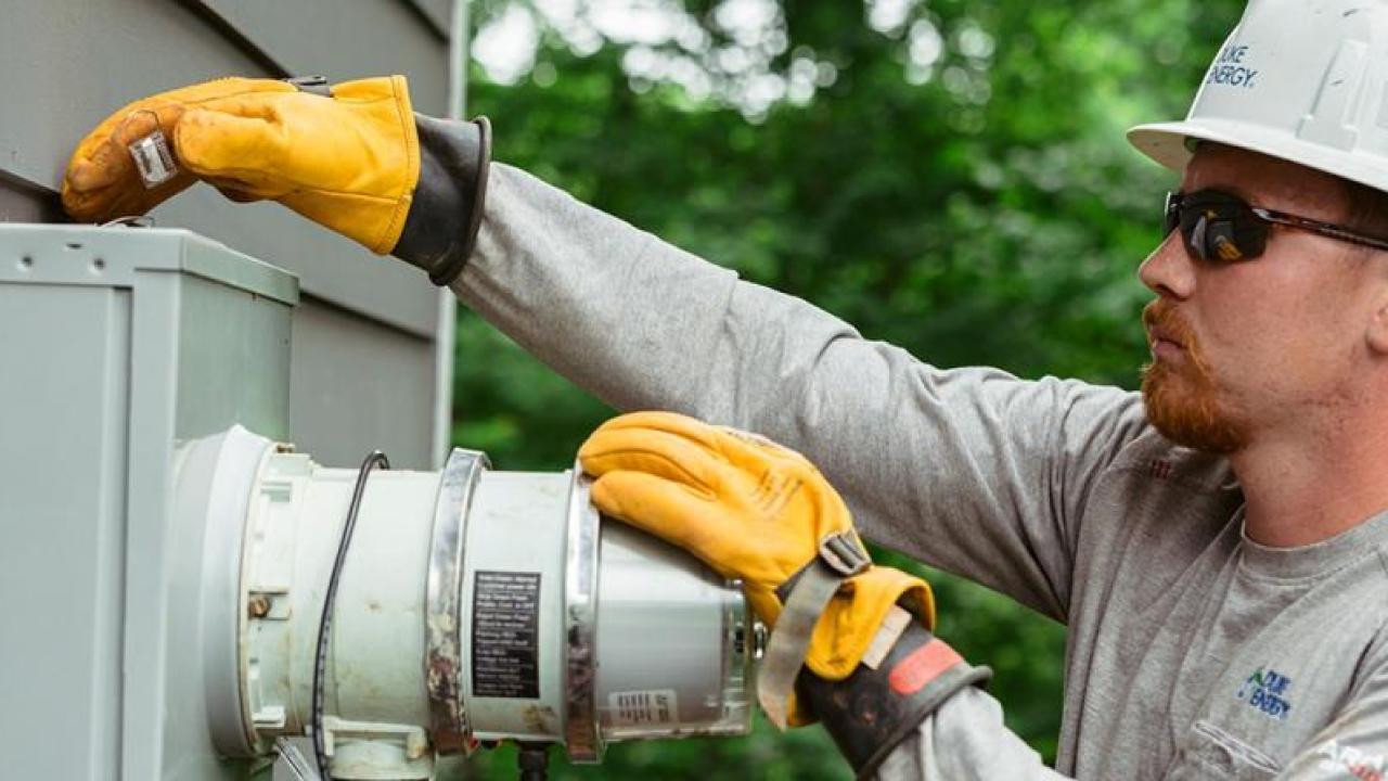 Harrison Cochran working on an electrical box, wearing protective gear.