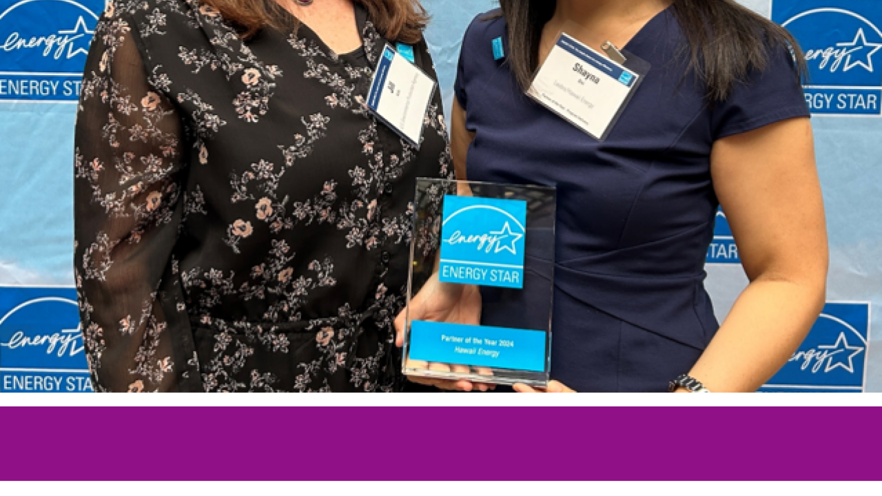 Two people posed holding an award. "Hawai'i Energy" logo at the bottom.